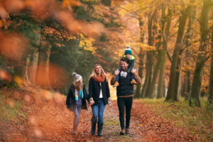 En familie der går i en skov i efterårsfarver